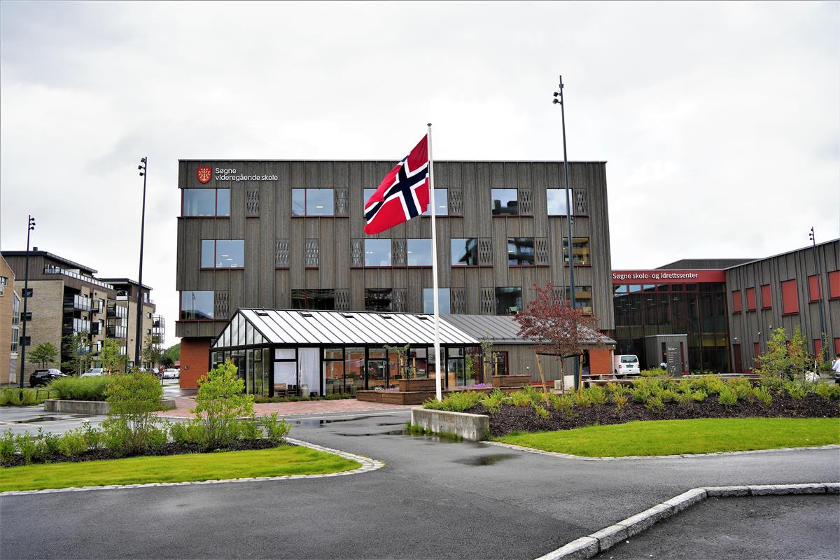 Det norske flagget og et skolebygg. Foto. - Klikk for stort bilde