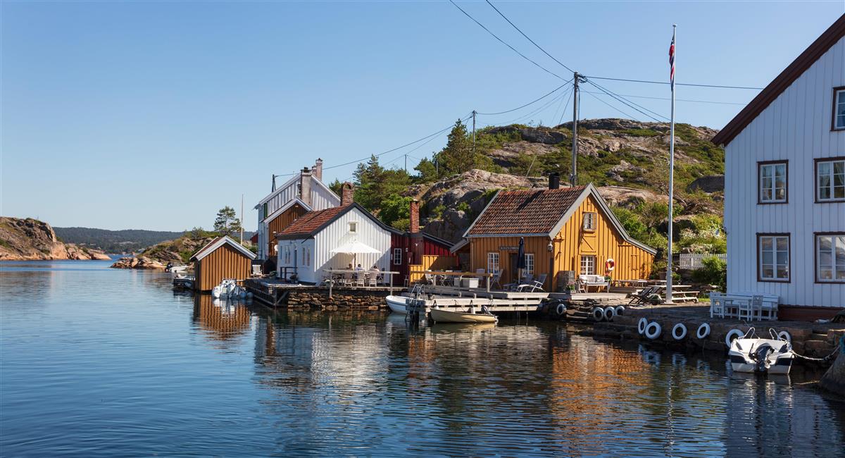 sjøhus, brygger, sjø og himmel. Fotografi
