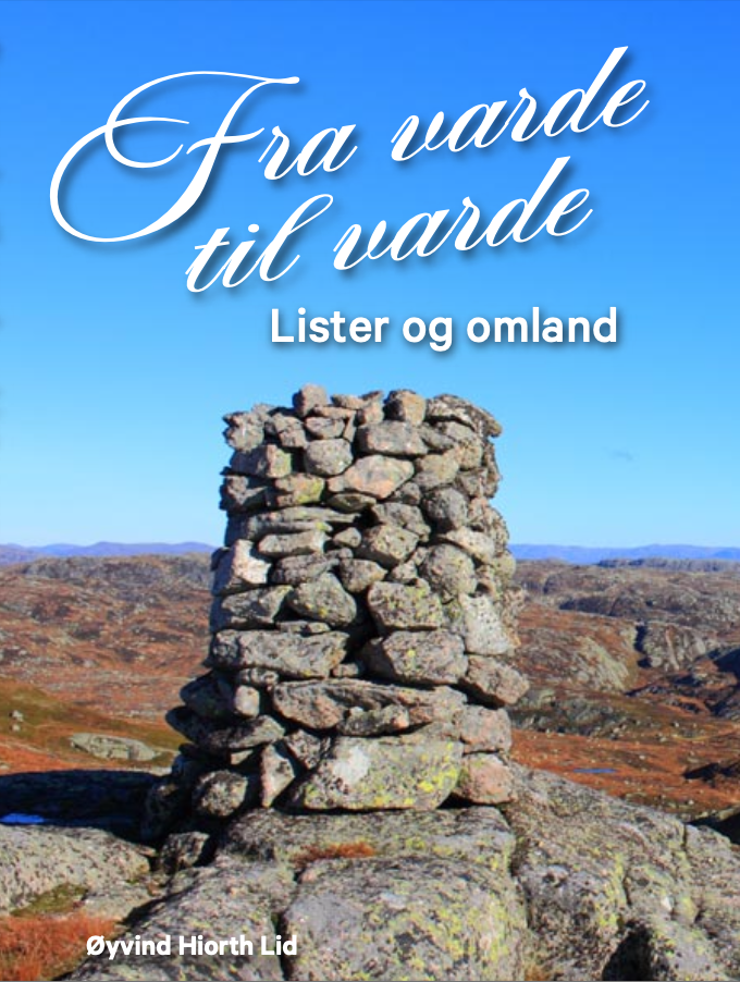 En høy varde laget av steiner på en fjelltop. I bakgrunnen er det et heilandskap. 